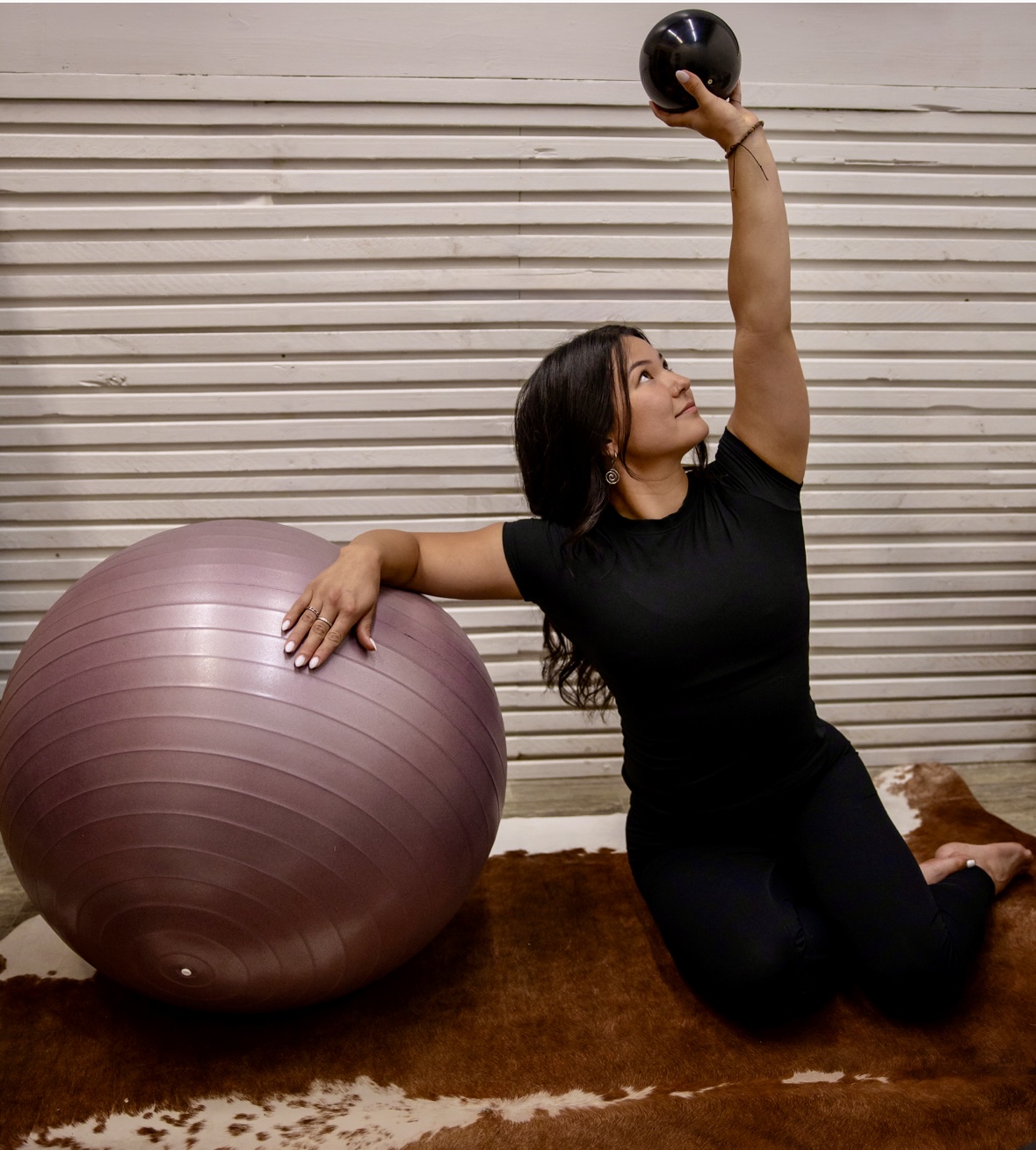 Kiarra holding a small weighted ball during a movement session
